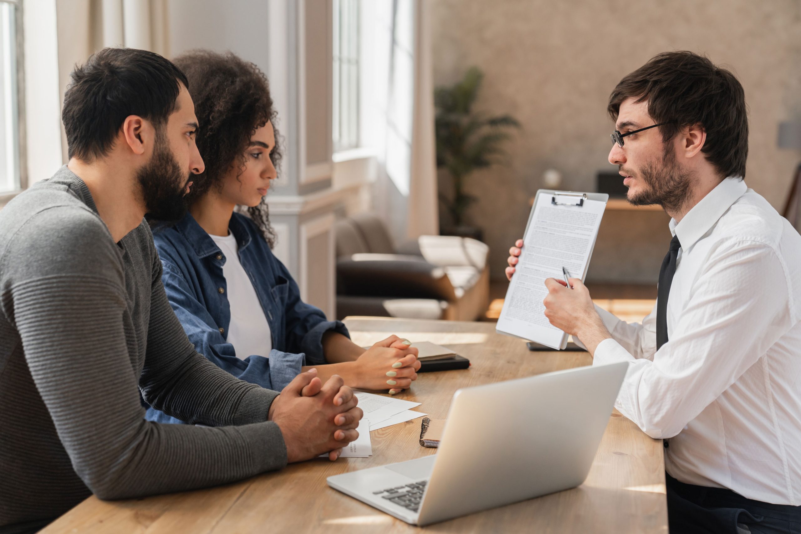 Couple meeting with representative showing them a document.