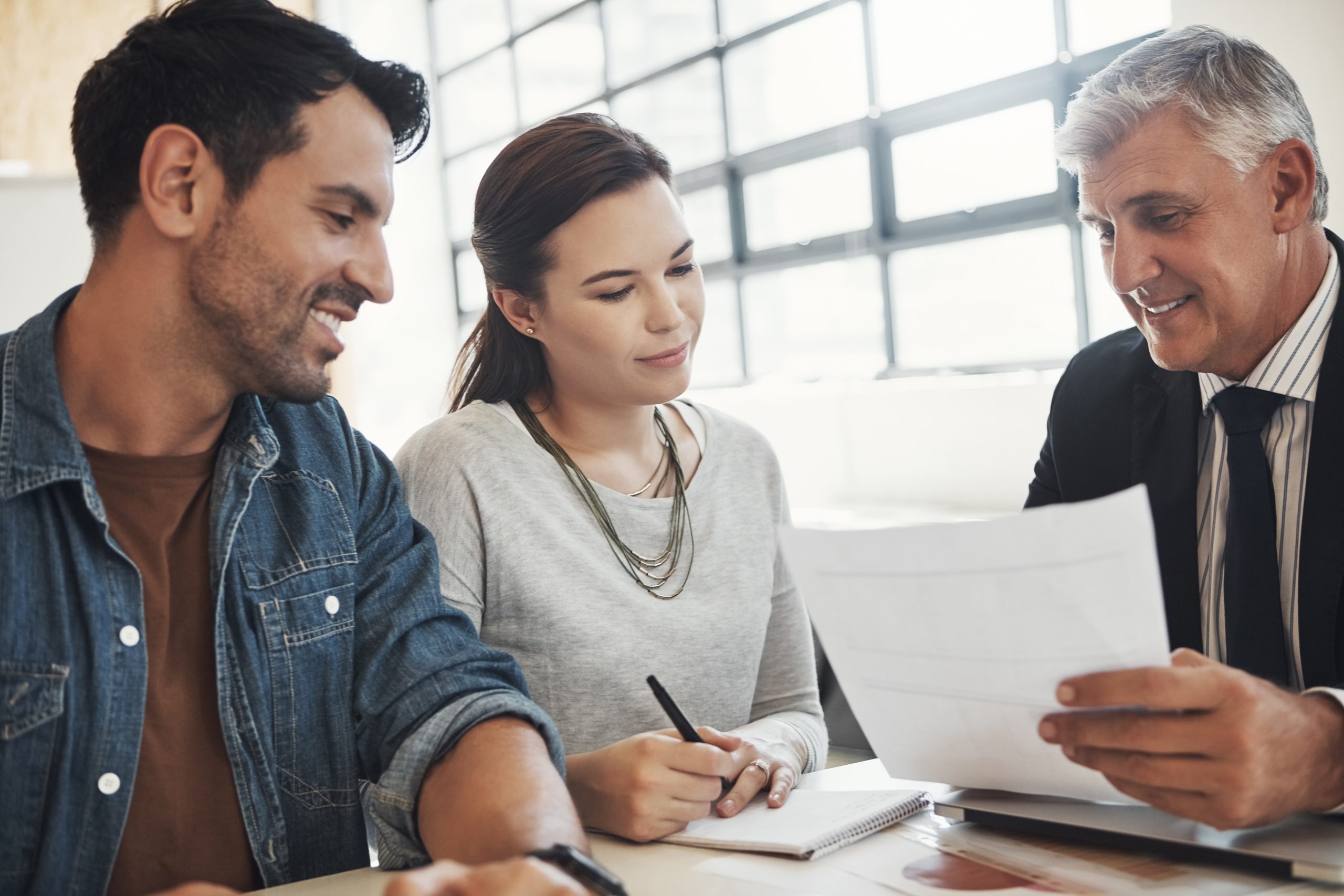 Couple talking with professional over paperwork